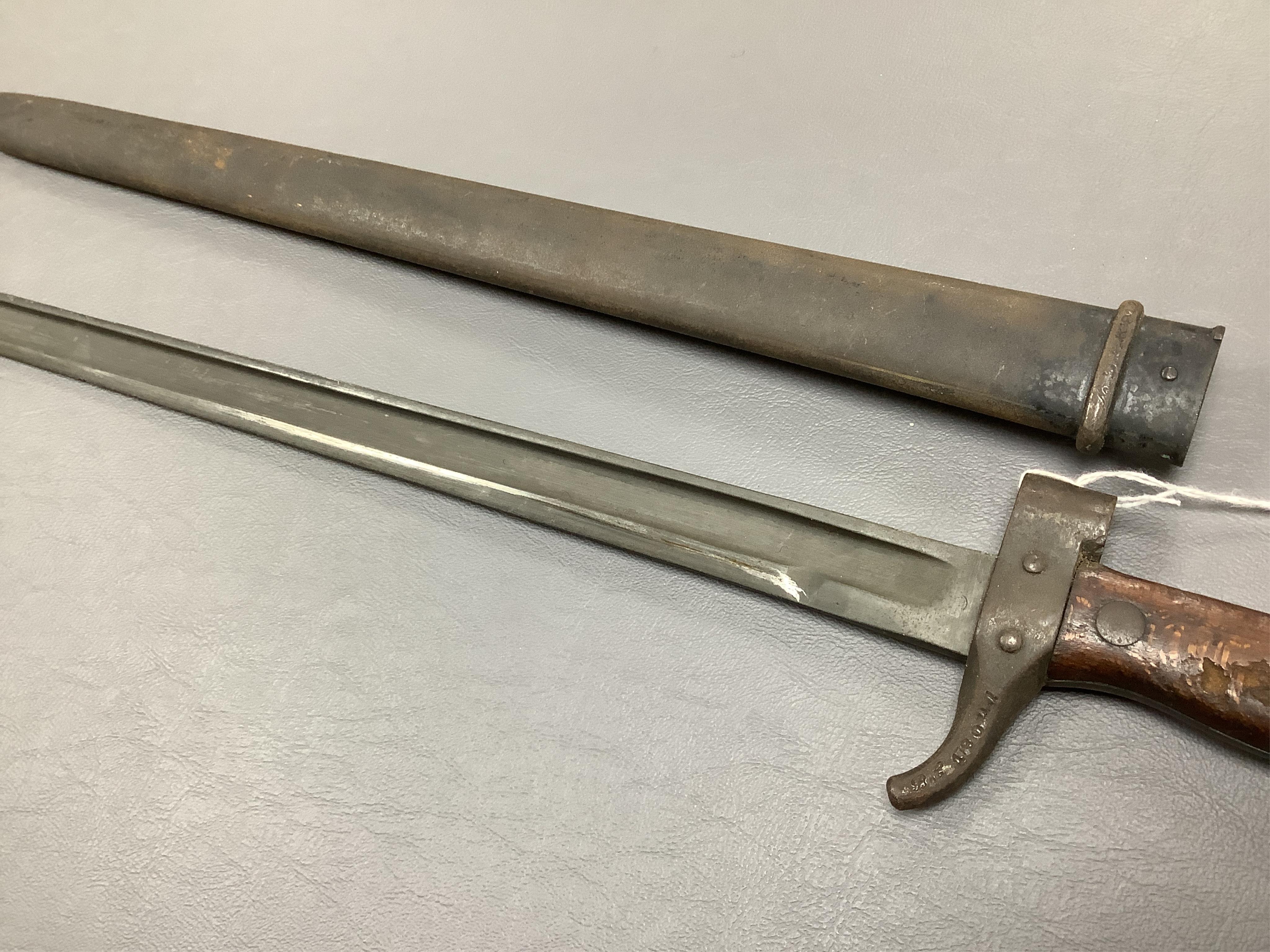 A First World War Turkish army officer’s sword, with pipe back blade, regulation iron guard pierced with crescent and moon, chequered horn grips, in its iron scabbard, together with an unidentified bayonet in its scabbar